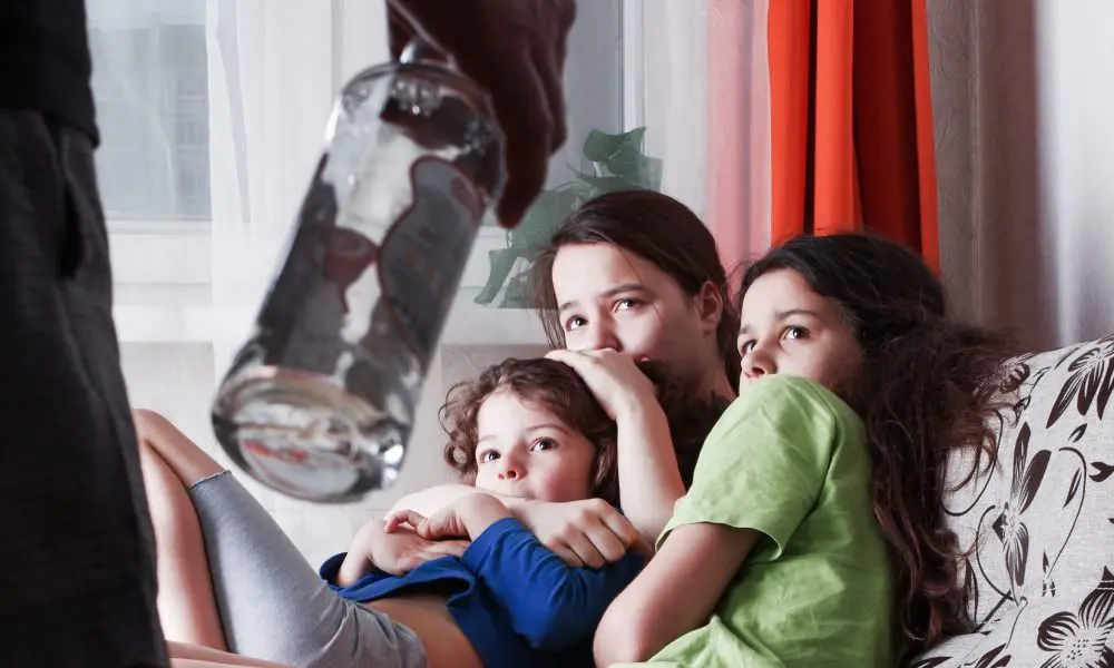 Children looking afraid while witnessing their parent struggling with alcohol addiction